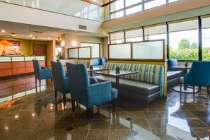 A hotel lobby with a seating area, a reception desk, and large windows. - Drury Inn & Suites Nashville Airport (Nashville)