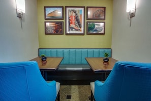 A restaurant with a booth seating area, framed pictures on the wall, and a small potted plant on the tables. - Drury Inn & Suites Nashville Airport (Nashville)