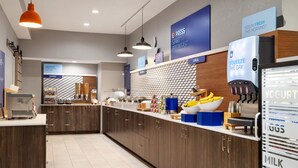 A modern kitchen with wooden cabinets, a breakfast bar, and a refrigerator stocked with dairy products. - Holiday Inn Express & Suites Opelousas by IHG (Opelousas)