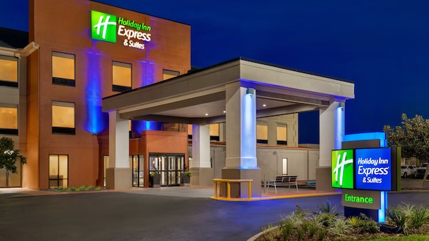 A Holiday Inn Express & Suites building with a covered entrance and a sign indicating the entrance. - Holiday Inn Express & Suites Opelousas by IHG (Opelousas)