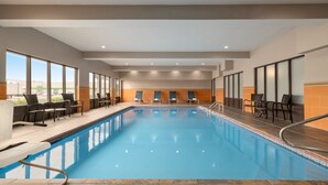 A modern indoor swimming pool with clear blue water, surrounded by lounge chairs and a tiled floor. - Holiday Inn Express & Suites Opelousas by IHG (Opelousas)