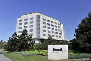 Ένα σύγχρονο κτίριο με μια επιγραφή που γράφει «ΞΕΝΟΔΟΧΕΙΟ ΡΕΖΕΝΤ ΒΑΡΣΟΒΙΑΣ» στην πρόσοψη.