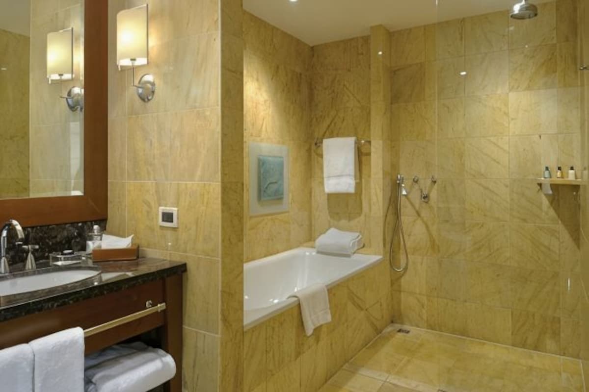 A bathroom with a bathtub, shower, and sink.