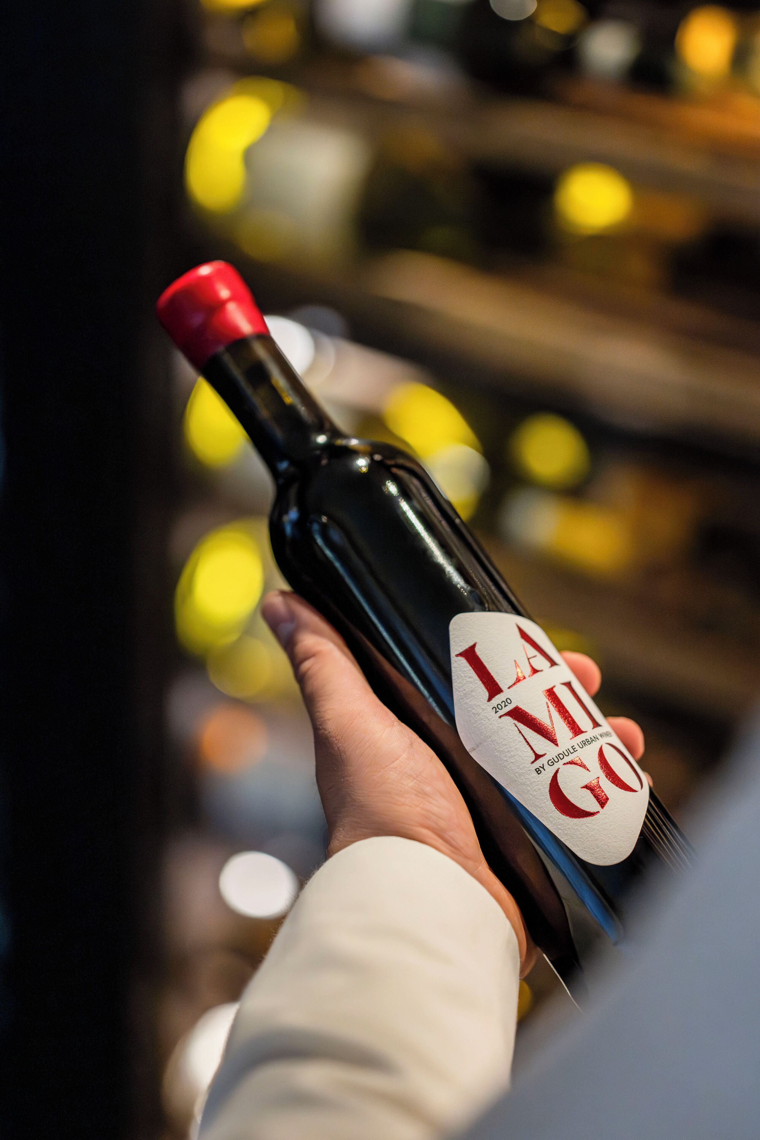 Uma mão segurando uma garrafa de vinho com um rótulo que diz 'LA MILE GOGO 2020'.