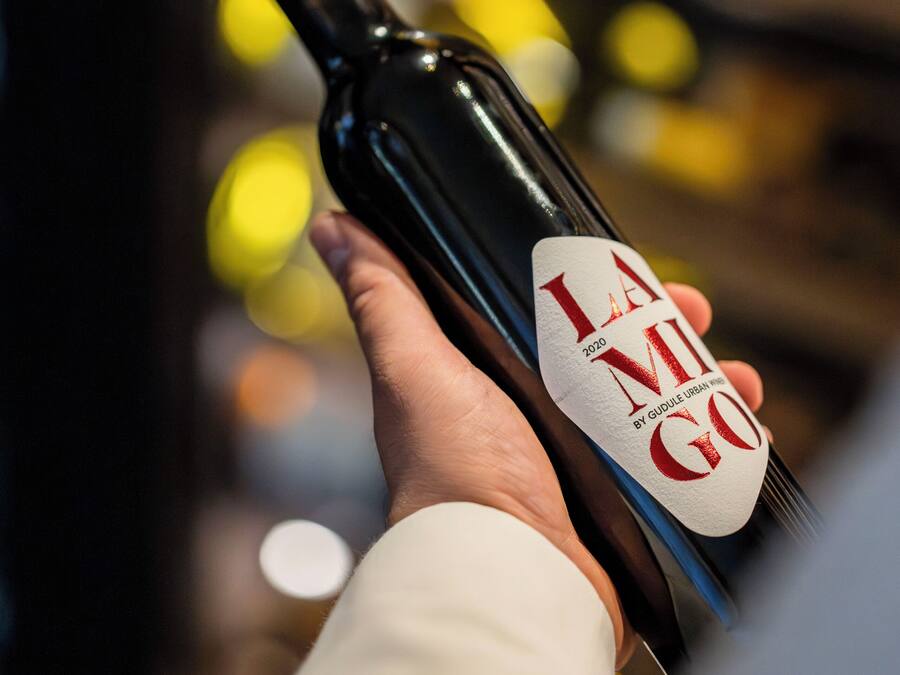 A hand holding a wine bottle with a label that reads "LA MILE GOGO 2020".