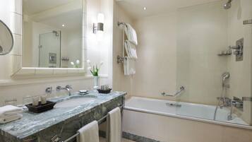 Une salle de bain moderne avec un lavabo en marbre, un grand miroir, une douche à parois de verre et une baignoire.