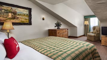 A bedroom with a bed, a dresser, a chair, a television, and a painting on the wall.