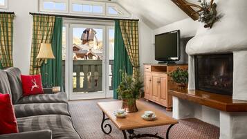 A cozy living room with a sofa, a coffee table, a fireplace, and a television.