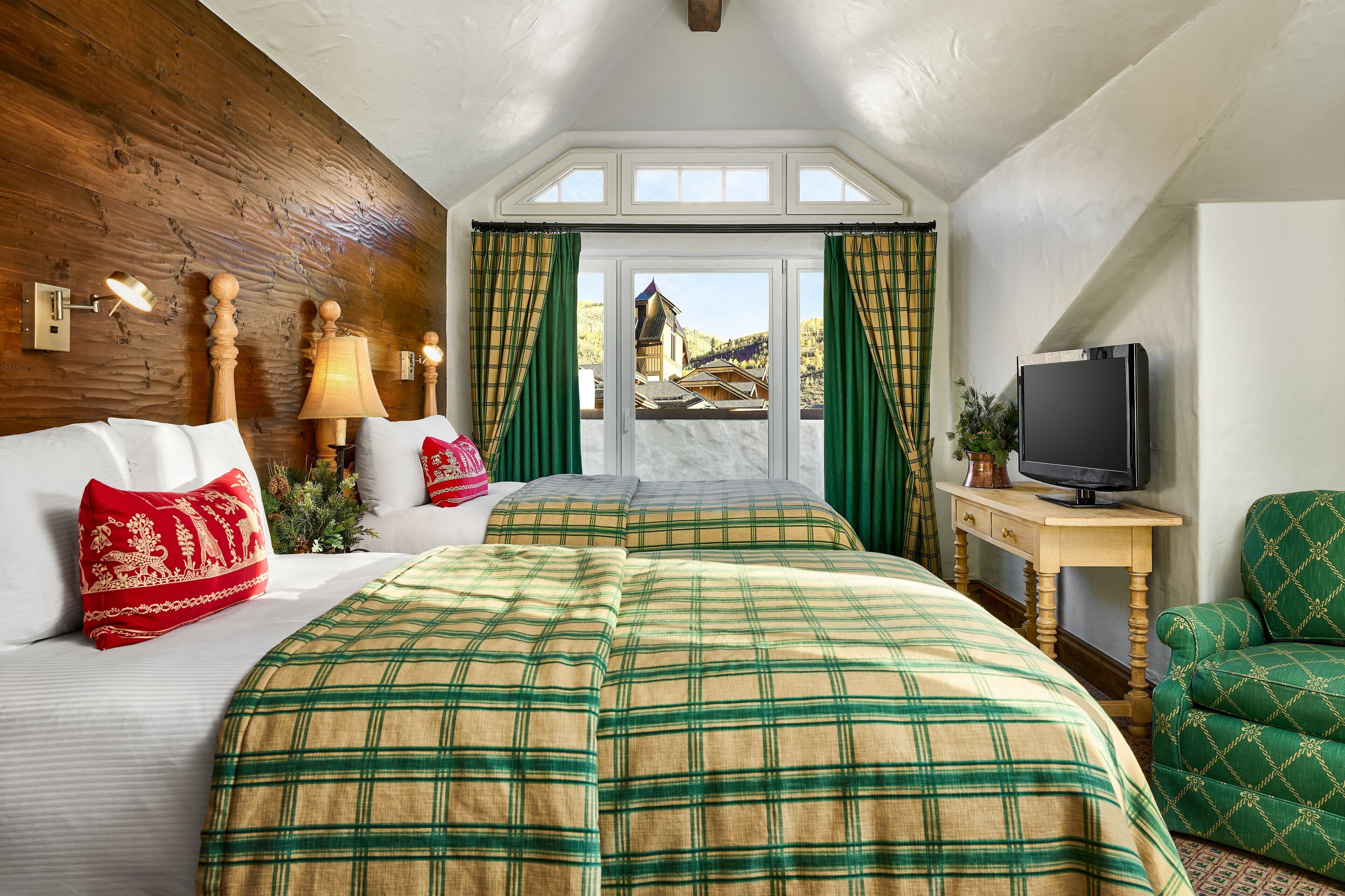 Un dormitorio con dos camas, una televisión y vistas a la montaña.