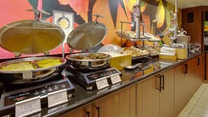 A buffet counter with labeled food stations including scrambled eggs, cheese omelet, and turkey sausage. - Fairfield Inn & Suites by Marriott San Francisco Airport (Millbrae)