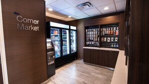 Une petite épicerie de quartier avec un présentoir réfrigéré et un distributeur automatique.