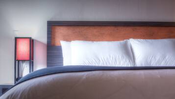 A neatly made bed with white pillows and a wooden headboard.