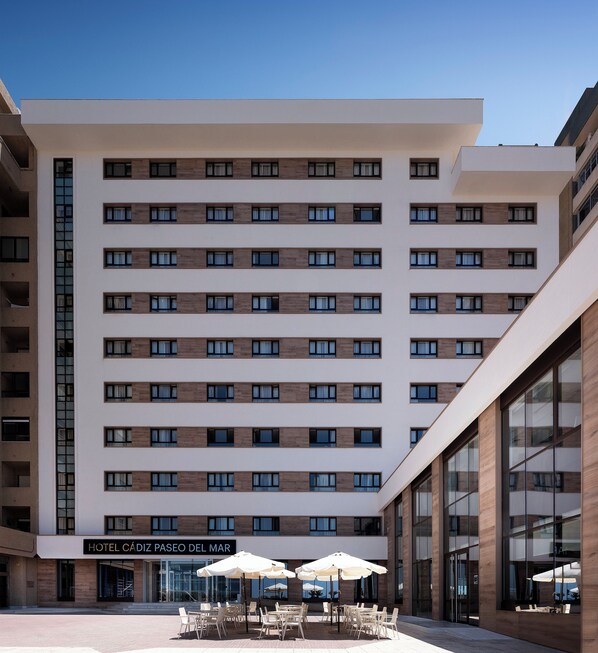 Experience the sleek, contemporary design of Hotel Cádiz Paseo del Mar, featuring a symmetrical facade with evenly spaced windows and a flat roof.