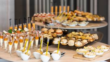 A buffet table with various food items and drinks.