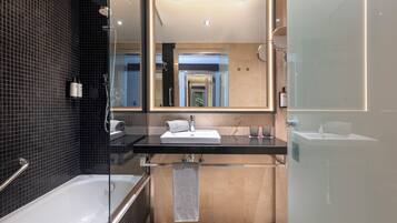 A modern bathroom with a glass-enclosed shower, a large mirror, a vanity with a sink, and a bathtub.