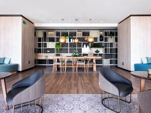 Work in style with a central table and four chairs, surrounded by plants and modern decor.