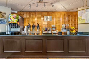 A coffee station with a coffee machine, a fruit dispenser, and a sign that says "Dream Cup."