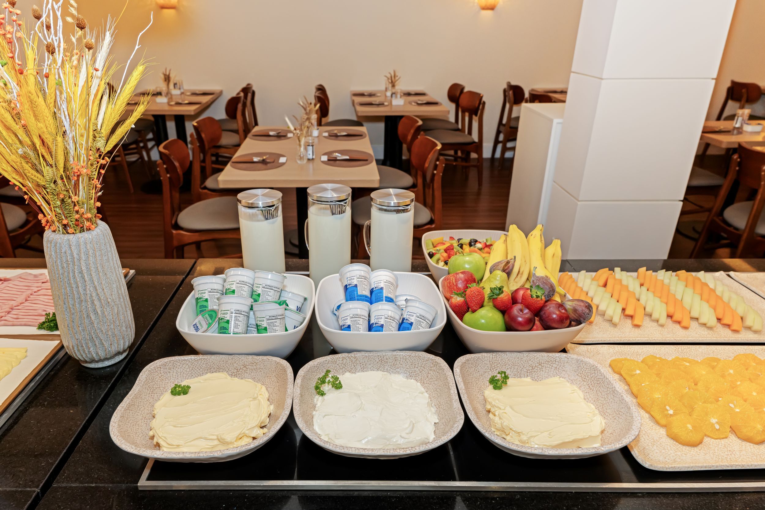 Un buffet con diversi cibi, tra cui frutta, latticini e bevande.