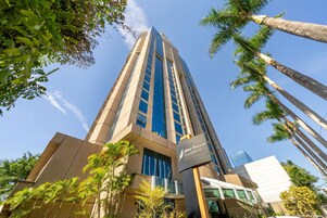 A tall, modern building with a glass facade and a sign indicating it is a hotel.