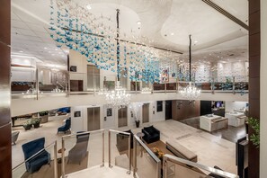 A spacious lobby with a modern chandelier, seating areas, and a glass railing overlooking the interior. - Blue Tree Premium Faria Lima (São Paulo)