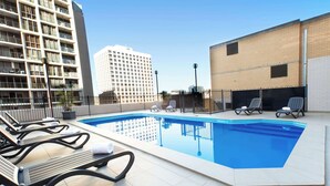 A rooftop swimming pool with lounge chairs and a view of surrounding buildings. - Metro Hotel Marlow Sydney Central (Haymarket)