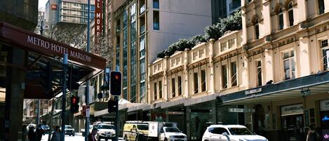A street view with the Metro Hotel Marlow sign, a Chamberlain store, and a white SUV parked on the side.