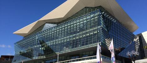 A modern building with a glass facade and a distinctive triangular roof.
