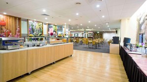 A self-serve breakfast area with a buffet, seating area, and a large window with a view. - Metro Hotel Marlow Sydney Central (Haymarket)