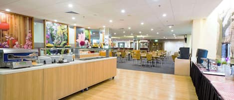 A self-serve breakfast area with a buffet, seating area, and a large window with a view.