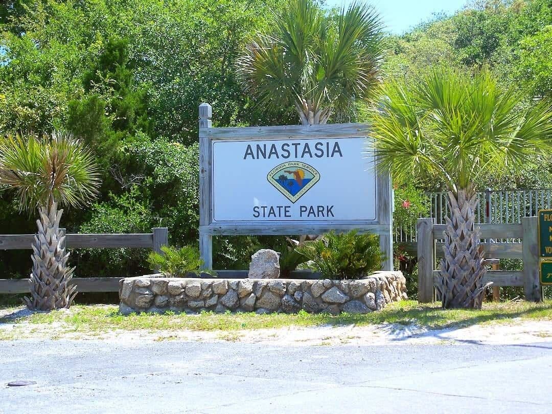 Señal para el Parque Estatal Anastasia, con un logotipo y un borde de piedra.