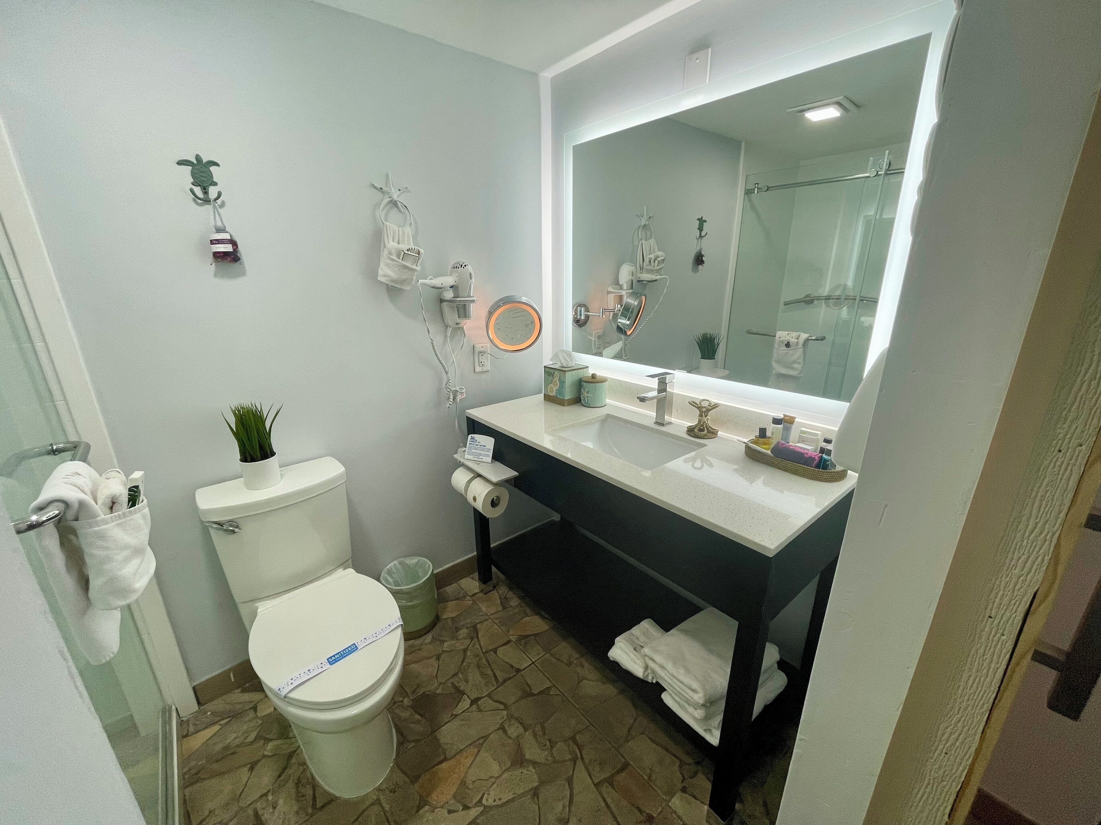 Et moderne badeværelse med toilet, bidet og et stort spejl.