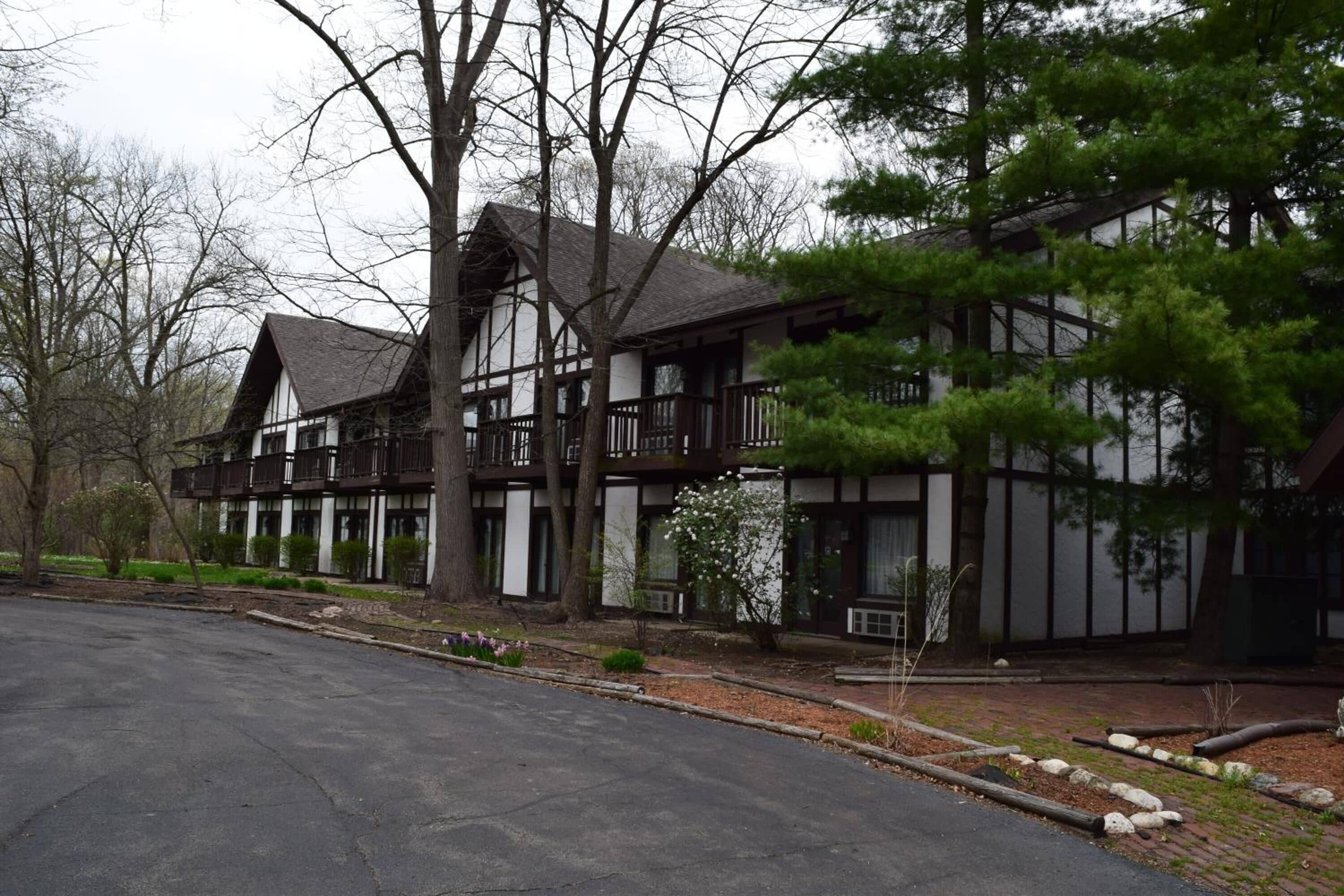 A two-story building with a symmetrical facade, large windows, and a balcony on the upper floor.