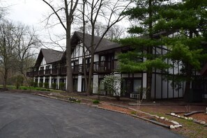 A two-story building with a symmetrical facade, large windows, and a balcony on the upper floor.