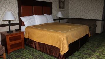 A hotel room with a bed, two bedside tables, a nightstand, a chair, a lamp, and a painting on the wall.