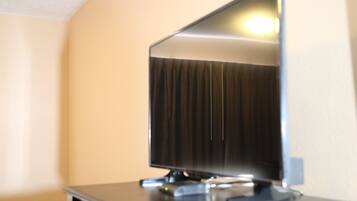 A television on a stand in a room with beige walls.