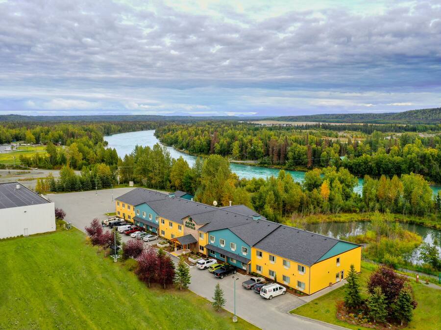 A multi-story hotel with a parking lot and a river view.