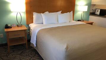 Une chambre d’hôtel avec un grand lit, deux tables de chevet et une tête de lit.