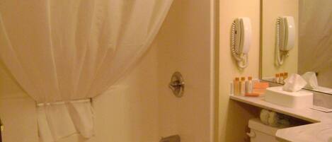 Un baño con bañera, inodoro y cortina de ducha.