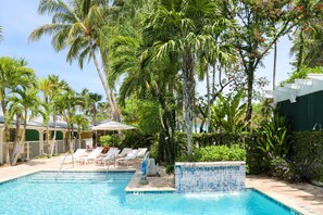 Una piscina al aire libre, sombrillas, tumbonas