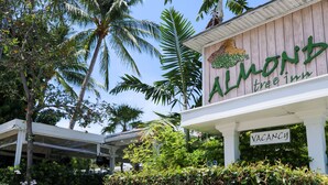 A building with a sign reading "ALMOND Frog & Toad Inn" and a "VACANCY" sign below it. - Almond Tree Inn Hotel - Adults Only (Key West)