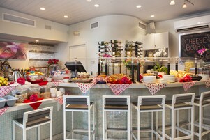 Zona de bar con mostrador que exhibe distintos alimentos y una pizarra con la carta.