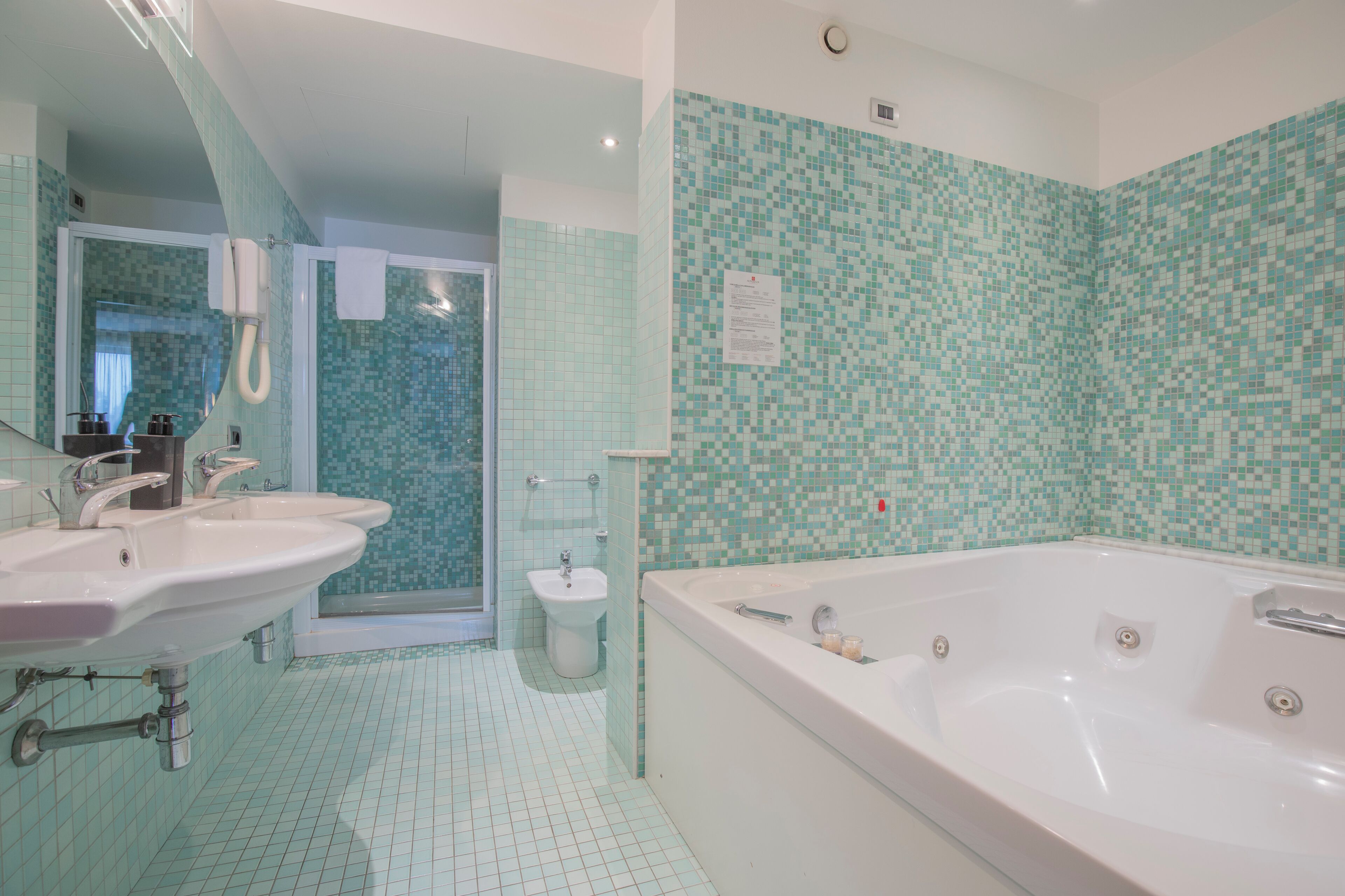 A bathroom with two sinks, a toilet, and a bathtub.