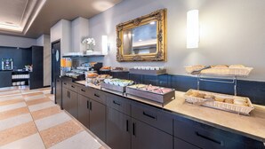 Un espace buffet proposant divers plats, un miroir et un luminaire fixé au mur.