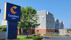 A Comfort Inn hotel with a modern building, a parking lot, and a small pool area. - Comfort Inn Bessemer Birmingham South (Bessemer)