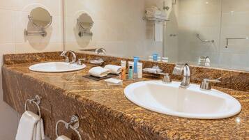 A bathroom with two sinks, a mirror, and a towel rack.