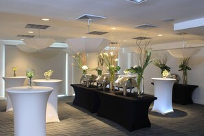 A modern hotel lobby with round tables, potted plants, and ceiling vents. - Radisson Hotel Panama Canal (Panama City)