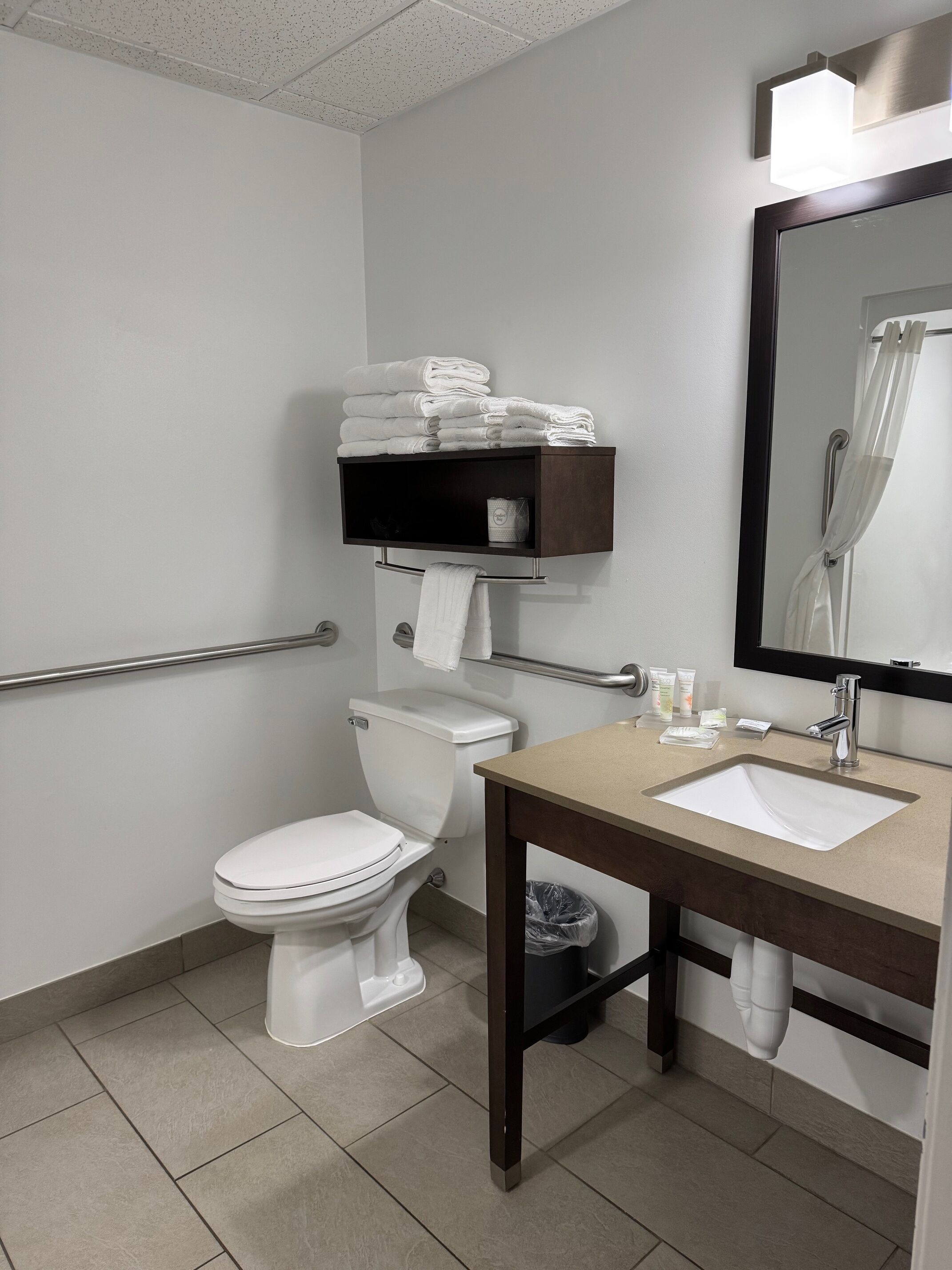Un baño moderno con inodoro, lavabo y espejo.