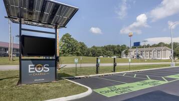 A solar panel installation with a charging station labeled "EOS CHARGE" and a McDonald's sign in the background.