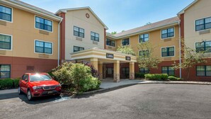 A multi-story hotel with a lobby entrance, numbered 329, and a red car parked in front. - Extended Stay America Suites Red Bank Middletown (Red Bank)