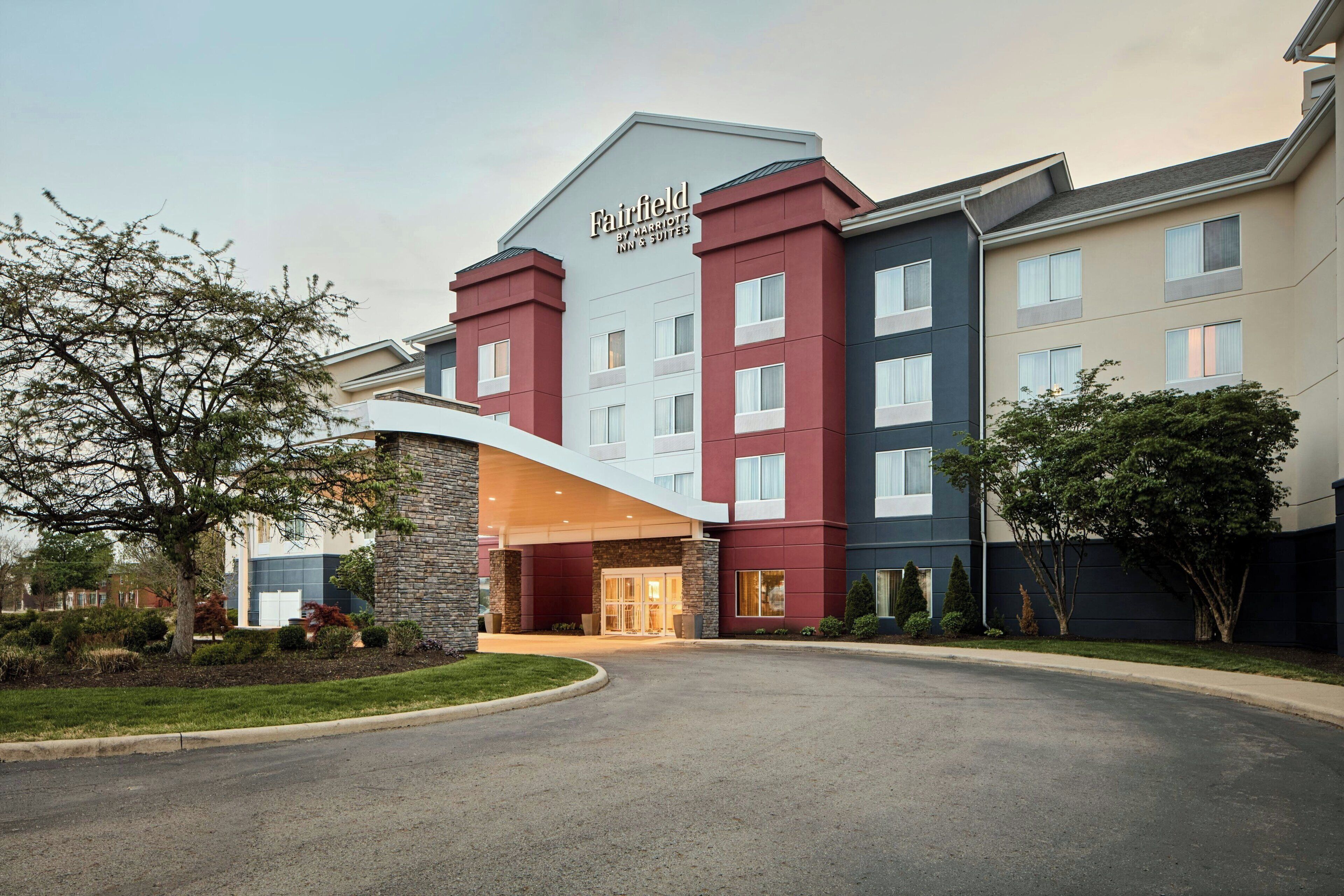 A hotel with a modern facade, a prominent entrance, and a landscaped driveway.